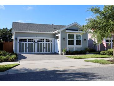 Charming single-story home featuring a two-car garage, well-manicured lawn, and beautiful exterior paint at 406 Alcove Dr, Groveland, FL 34736
