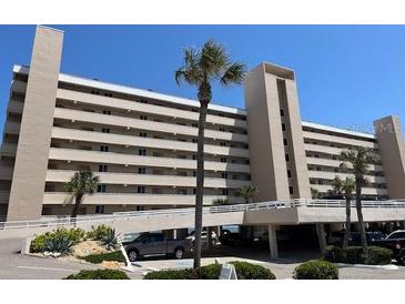 Beachside condo building featuring a parking garage, palm trees, and multiple balconies at 4453 S Atlantic Ave # 602, Ponce Inlet, FL 32127