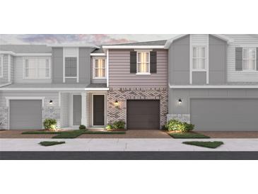 New townhome boasts gray brick facade, garage, lush landscaping and sidewalks for pedestrian-friendly living at 560 Southern Edge Way, Sanford, FL 32771