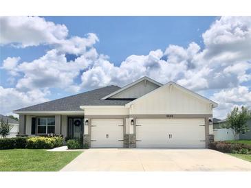 Charming single Gathering home boasts a two-car garage, landscaped yard and welcoming entryway at 6686 Treymont Dr, Lakeland, FL 33813