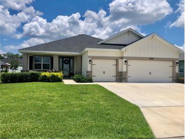 Charming single-story home with a well-manicured lawn and a three-car garage at 6686 Treymont Dr, Lakeland, FL 33813