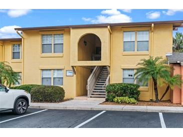 Inviting yellow condo building with well-kept landscaping and convenient parking at 758 E Michigan St # 208, Orlando, FL 32806