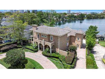 Stunning Mediterranean-style home featuring a tile roof, arched entry, and lush landscaping with a brick-paved driveway at 1010 Terrace Blvd, Orlando, FL 32803
