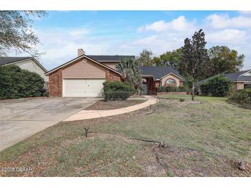 Charming single-Gathering home with a well-maintained lawn, brick accents, and an attached two-car garage at 13 Bass Lake Dr, Debary, FL 32713