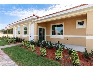 Charming single-story home with a terracotta roof, manicured lawn, and inviting front porch at 1800 Coriander Dr, Kissimmee, FL 34759