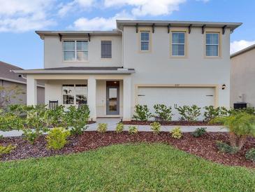 Charming two-story home with landscaped yard, inviting front porch, and a two-car garage at 3326 Wynwood Forest, Ocoee, FL 34761