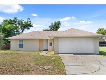 Charming single-story home with a well-manicured lawn, attached two-car garage, and neutral-colored exterior at 831 Lindley Blvd, Deland, FL 32724