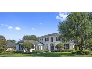 Beautiful two-story home with manicured lawn, lush landscaping, and classic architectural details at 968 Ashton Oaks Cir, Lakeland, FL 33813