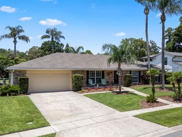 Charming one-story home with a two-car garage, lush landscaping, and inviting front porch seating at 986 Stonewood Ln, Maitland, FL 32751