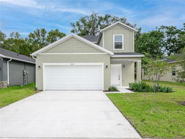 Charming home featuring a two-car garage, manicured lawn, and classic architectural details at 164 14Th Ave, Longwood, FL 32750