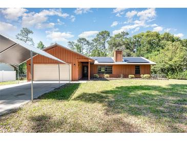 Charming single-story home with a cozy appeal, featuring a lush front lawn and attached garage with covered parking at 175 Cliff St, Deland, FL 32720