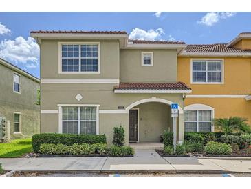 Inviting two-story townhome with a tile roof, manicured landscaping, and an accessible entrance at 3055 Beach Palm Ave, Kissimmee, FL 34747