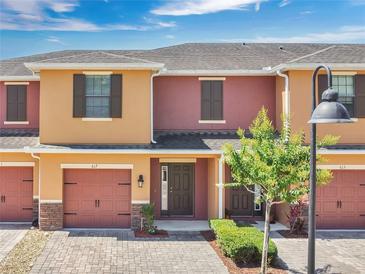 Charming townhome featuring a brick driveway, a one car garage, and inviting curb appeal with landscaping at 617 Joyful Blossom Pl, Longwood, FL 32750