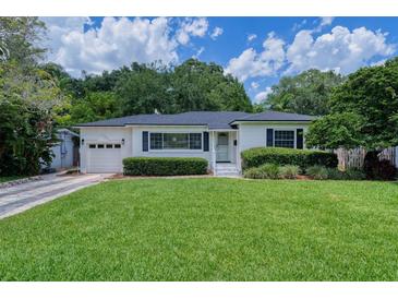 Charming single-story home features a lush green lawn, well-manicured hedges, and an attached one car garage at 915 Oregon St, Orlando, FL 32803