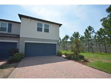 Charming two-story home with a two-car garage and neatly manicured landscaping, with a brick driveway at 971 Desert Candle Dr, Ocoee, FL 34761