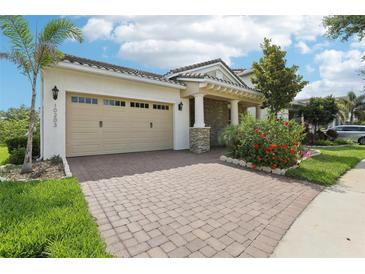 Charming single-story home with a brick driveway, lush landscaping, and a welcoming covered entrance at 10203 Henbury St, Orlando, FL 32832