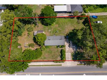 An aerial view shows the location and exterior of this home within a tree-lined lot at 1121 Votaw Rd, Apopka, FL 32703