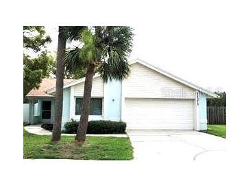 Charming one-story home with a two-car garage, featuring two palm trees in the front yard at 11373 Darlington Dr, Orlando, FL 32837