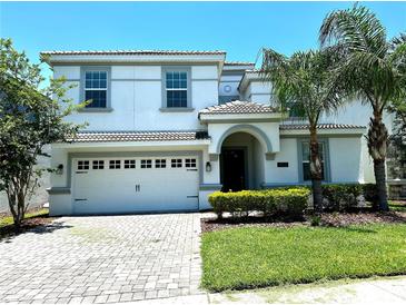 Charming two-story home featuring a two-car garage, tiled roof, and well-manicured landscaping at 1513 Maidstone Ct, Davenport, FL 33896