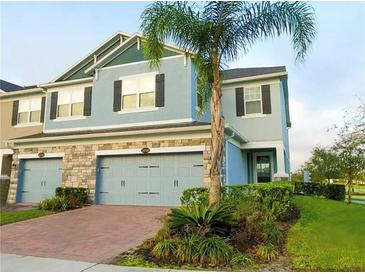 Charming townhome with a two-car garage and lush landscaping at 15708 Orange Harvest Loop, Winter Garden, FL 34787