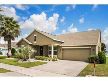 Inviting single-Gathering home featuring lush landscaping, a well-maintained lawn, and a two-car garage at 259 Blue Cypress Dr, Groveland, FL 34736