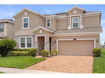Beautiful two-story home featuring a brick paver driveway, two-car garage, and stone accents at 2940 Nottel Dr, St Cloud, FL 34772