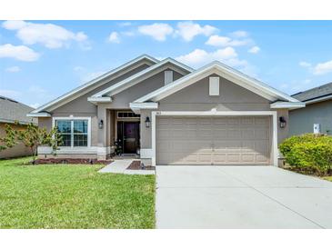 Charming single-story home with a well-manicured lawn, a two-car garage, and a welcoming entryway at 503 Meadow Pointe Dr, Haines City, FL 33844