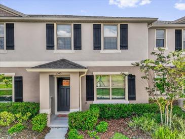 Charming townhome featuring a well-manicured lawn and black shutters that accentuate the gray facade at 1555 Dawnview Way, Kissimmee, FL 34744
