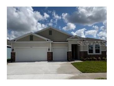 Charming single-story home featuring a 2-car garage, manicured lawn, and welcoming entrance at 2092 Ashwood Bluff Dr, Ocoee, FL 34761