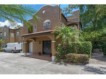 Charming two-story home featuring a covered entryway, red tile roof, and lush tropical landscaping in a well-maintained community at 2238 Hawick Ln # 2238, Winter Park, FL 32792