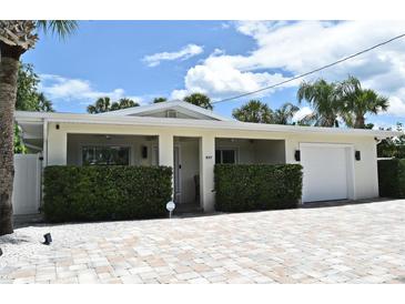 Charming single-story home featuring a manicured lawn, brick driveway, and an attached one car garage at 507 N Peninsula Ave, New Smyrna Beach, FL 32169