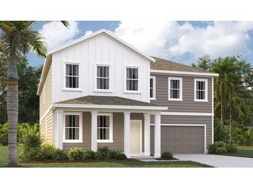 Charming two-story home with a covered front porch, complemented by lush landscaping and a two-car garage at 710 Junonia Blvd, New Smyrna Beach, FL 32168