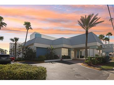 Stunning exterior view of Ocean Jewels Club with lush landscaping and palm trees at 935 S Atlantic Ave # 302, Daytona Beach, FL 32118