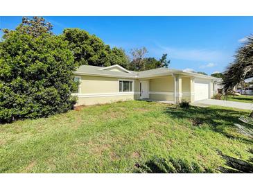 Charming single-story home featuring a well-maintained lawn and attached two-car garage at 10350 Sw 62Nd Terrace Rd, Ocala, FL 34476