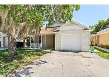 Charming home featuring a one-car garage, well-kept lawn, and inviting front porch at 13146 Odyssey Lake Way, Orlando, FL 32826