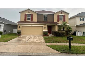 Two-story home featuring a two-car garage, red shutters, and a well-maintained front lawn at 1325 Bella Coola Dr, Orlando, FL 32828