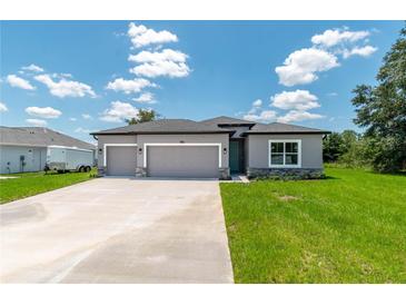 Charming single-story home featuring a three-car garage and neutral gray stucco exterior with stone accents at 506 Marion Oaks Trl, Ocala, FL 34473