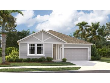 Charming single-story home featuring a light gray facade, well-manicured lawn and a two-car garage at 706 Junonia Blvd, New Smyrna Beach, FL 32168
