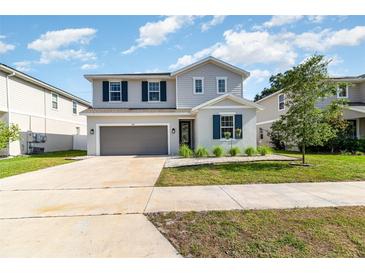 Charming two-story home featuring a well-manicured lawn, attached two-car garage, and tasteful gray exterior at 1073 River Otter Way, Deland, FL 32720
