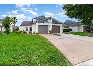 Charming home featuring a well-manicured lawn and a two-car garage with a classic design, creating curb appeal at 109 Lakepointe Cir, Kissimmee, FL 34743