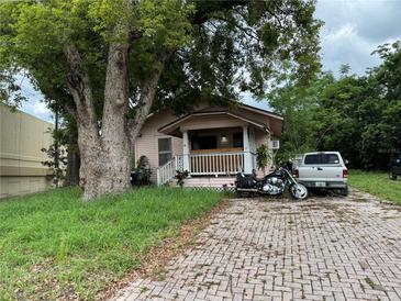 Charming home featuring a cozy porch, brick driveway, and mature trees enhancing curb appeal at 1996 Indiana Ave, Winter Park, FL 32789