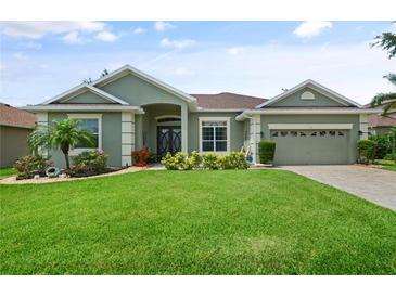 Beautiful single-story home with lush lawn, mature landscaping, and inviting entryway at 3696 Peacepipe Ct, Clermont, FL 34711