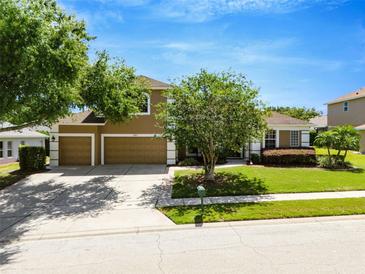 Charming two-story home boasting a well-manicured lawn, mature trees, and a three-car garage at 887 Lancer Cir, Ocoee, FL 34761