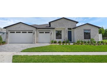 Beautiful single Gathering home featuring a lush lawn, brick facade, and a two car garage at 9265 Eagles Perch Pl, Orlando, FL 32825