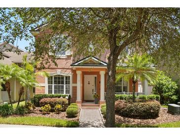 Charming two-story home featuring a welcoming front porch, manicured landscaping, and a brick walkway at 14781 Old Thicket Trce, Winter Garden, FL 34787
