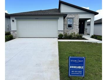 Charming single-story home with stone accents, a two-car garage, and a well-manicured lawn at 3087 Sunset Hills Rd, Winter Haven, FL 33881