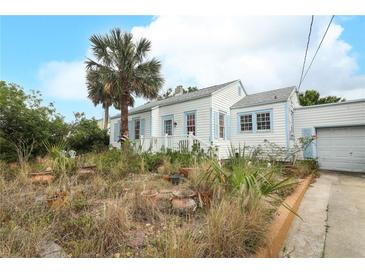 Charming exterior showcasing a two-story home with a quaint front yard and lush landscaping at 330 Phoenix Ave, Daytona Beach, FL 32118