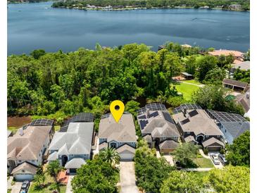 Stunning aerial view of lakefront home with lush green landscaping and solar panels on roof at 334 N Shadowbay Blvd, Longwood, FL 32779