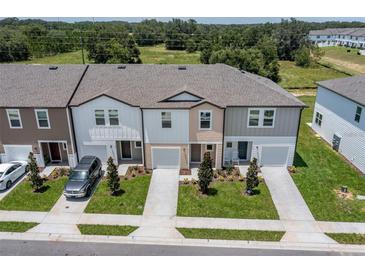 Charming townhomes featuring varied exterior colors, attached garages, and manicured lawns at 3435 Vesara Dr, Davenport, FL 33837