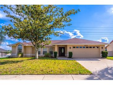 Charming single-story home showcasing a well-manicured lawn and attached two car garage at 554 Appleton Pl, Oviedo, FL 32765